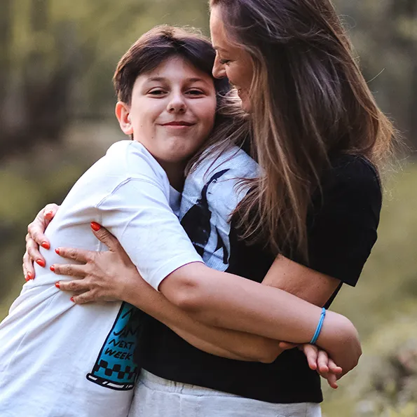 Mãe e filho adolescente abraçados